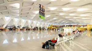 Private driver greeting traveler at Marrakech airport arrivals hall for an Amoudo Journeys transfer